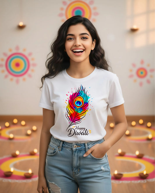 Woman wearing a white t-shirt with a colorful feather design and 'Happy Diwali' text, standing in front of Diwali decorations.